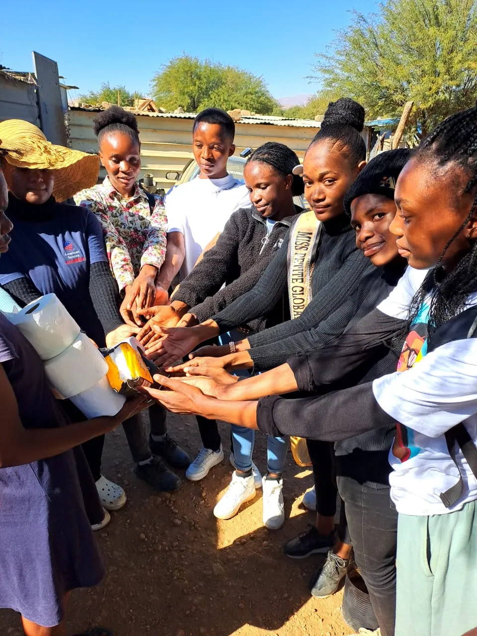 Young Kenyan women joining hands during a U-MATTER empowerment activity