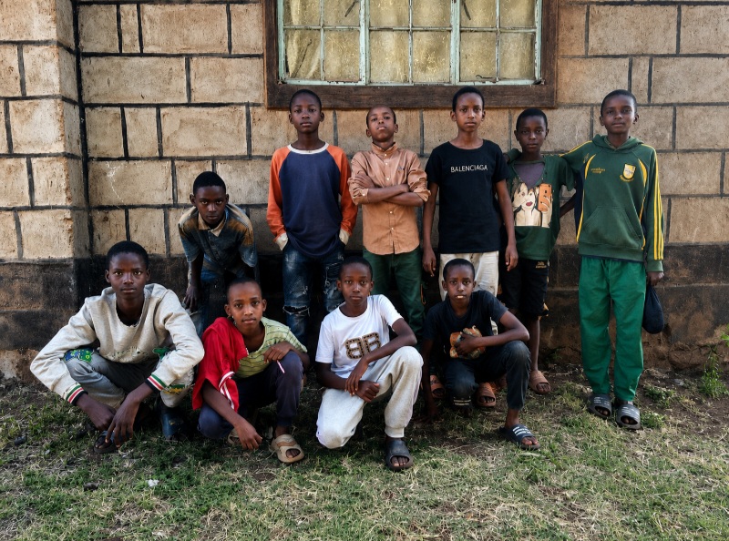 A group of teenagers together outside against a stone wall after a U-MATTER session