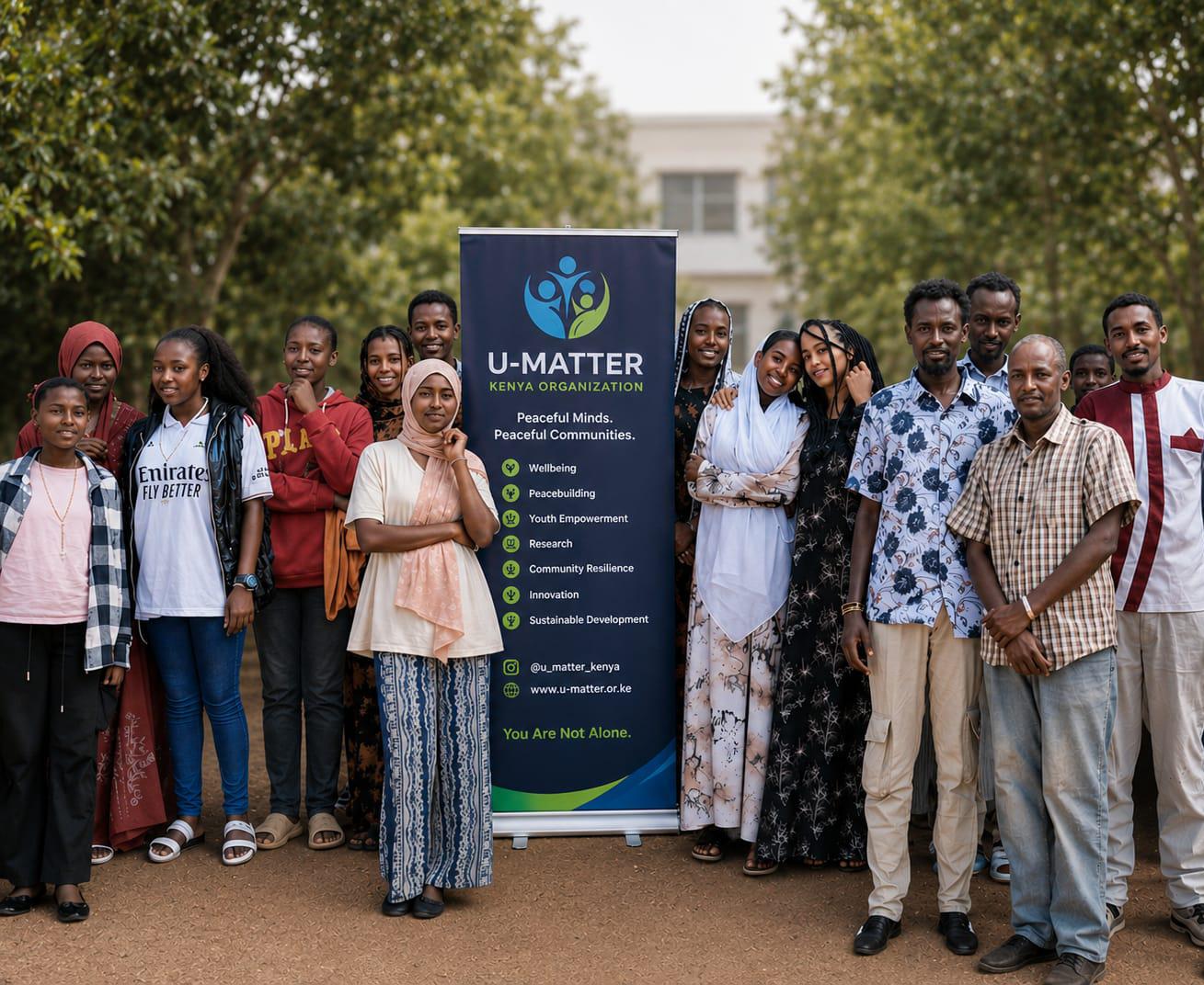 U-MATTER Kenya community members standing beside the organization's banner